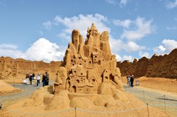 Søndervig sandskulptur, som forestiller huse bygget ind i et bjerg