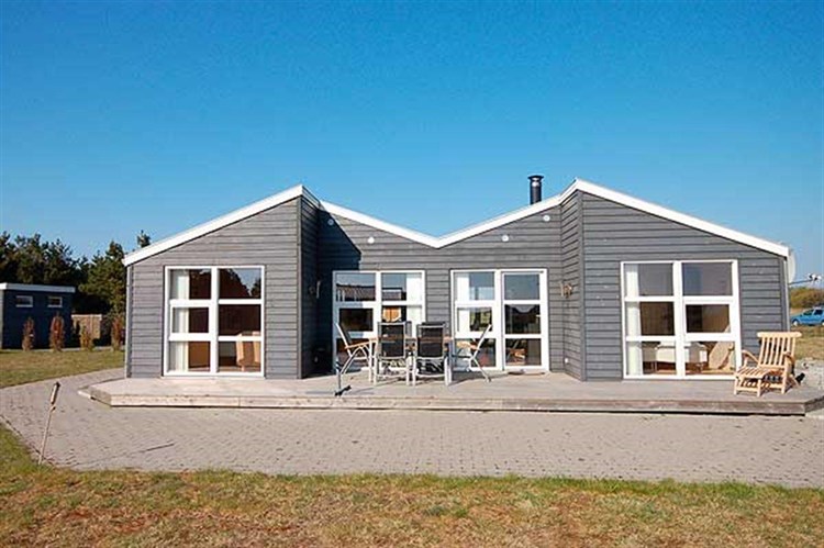 Moderne og spændende sommerhus til 8 personer, bygget i træ i 2006. Huset er beliggende i rolige omgivelser på en velplejet naturgrund i Stauning.