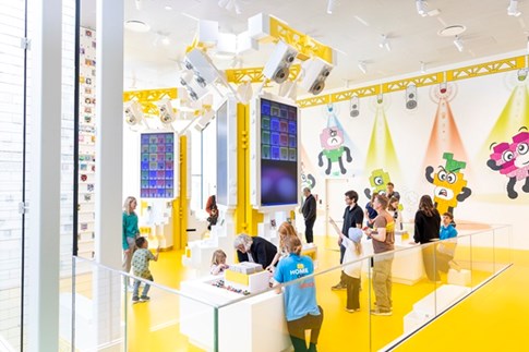 Børn og voksne udforsker den gule zone i LEGO® House