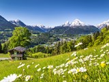 Idyllisk bjergslandskab i de bayriske alper med landsbyen Berchtesgarden i baggrunden
