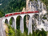 Et passagertog, der krydser Landwasser Viaduct i Graubünden i Schweiz