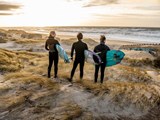 3 surfere på stranden i Klitmøller