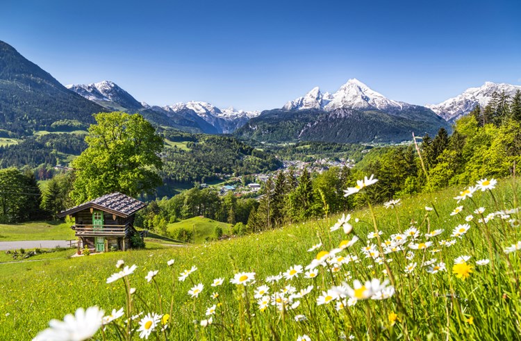 Idyllisk bjergslandskab i de bayriske alper med landsbyen Berchtesgarden i baggrunden