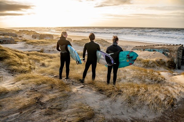 3 surfere på stranden i Klitmøller