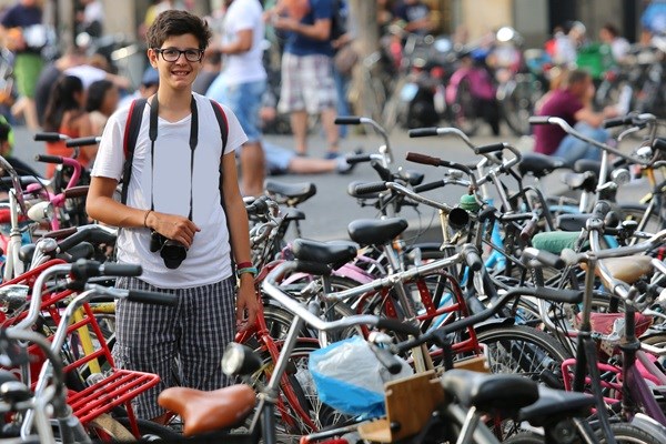 Teenager i Amsterdam blandt et hav af cykler