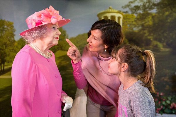 En mor og hendes datter kigger på en voksfigur af Dronning Elizabeth