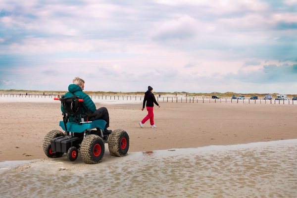 En mand i en elektrisk strandkørestol 