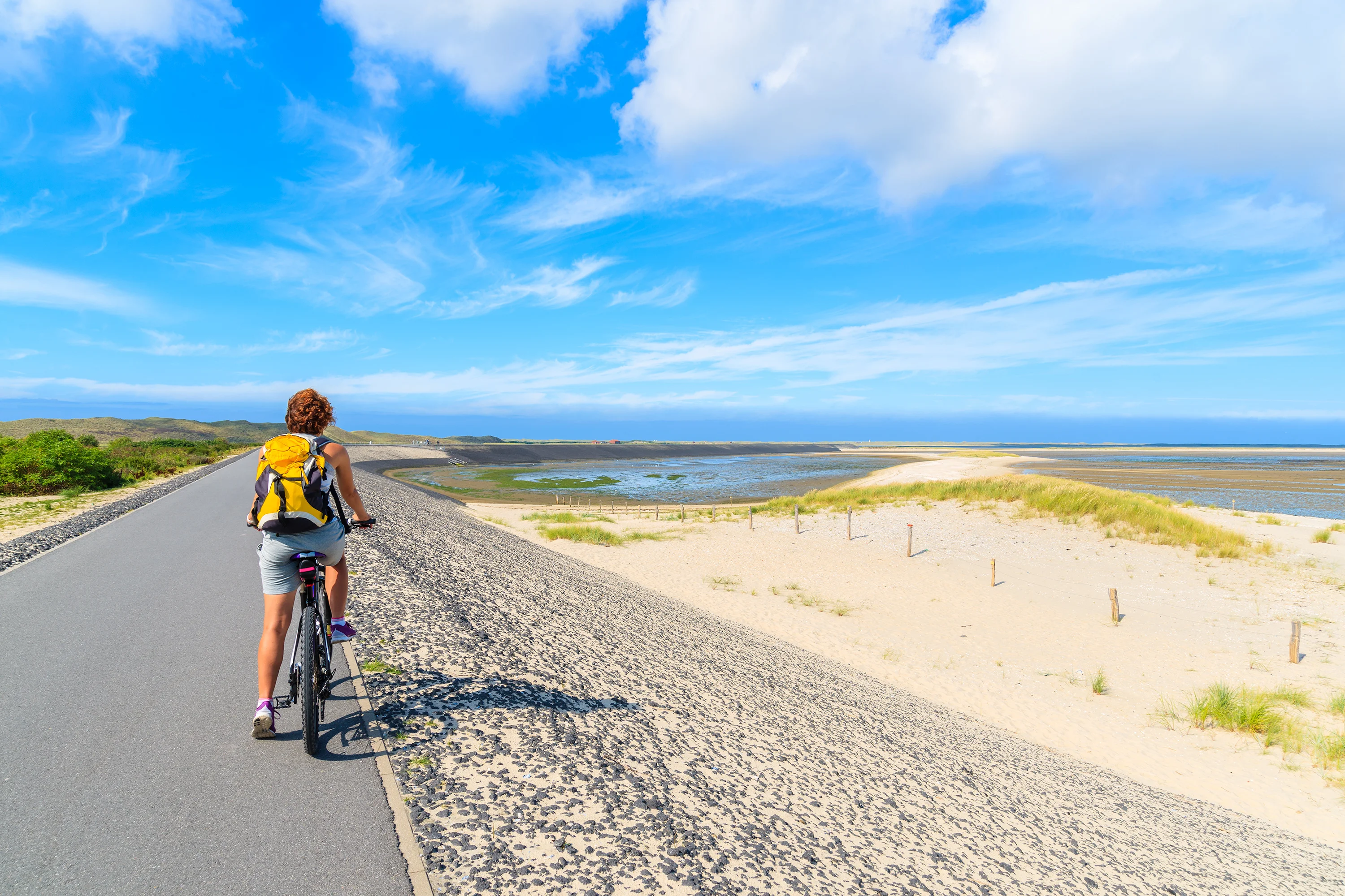 En kvinde på cykel ved stranden på Sylt