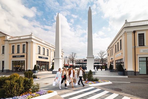 Fire unge mennesker med indkøbsposer i Designer Outlet Neumünster