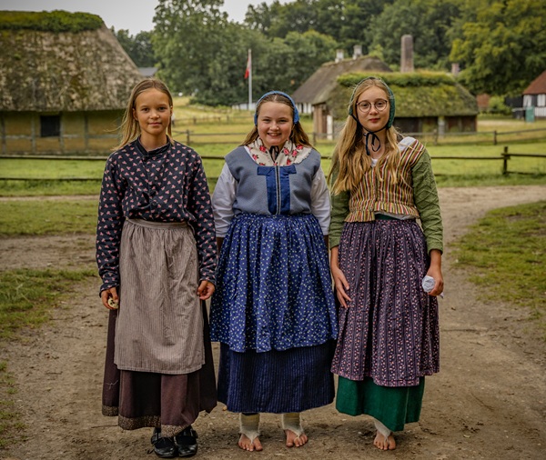 Tre piger i tidstypiske dragter på Hjerl Hede