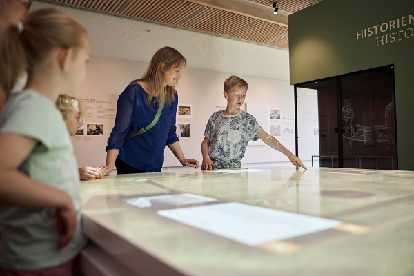 Oplevelsescenter personer ved lysbord