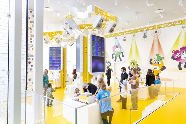 Børn og voksne udforsker den gule zone i LEGO® House